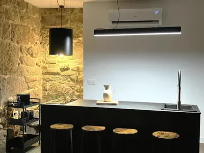 a kitchen with a counter with a vase and stools at O Luar in Piñeira Seca