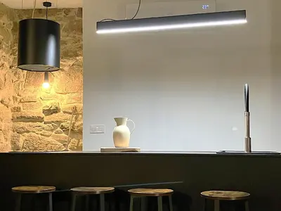 a counter with stools and a vase and a light at O Luar in Piñeira Seca