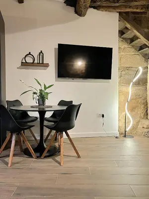 a dining room with a table and chairs and a tv at O Luar in Piñeira Seca