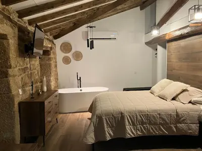 a bedroom with a bed and a bath tub at O Luar in Piñeira Seca