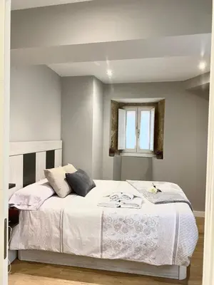 a bedroom with a bed with white sheets and a window at Pension A Casiña D,avoa Oseira in Osera
