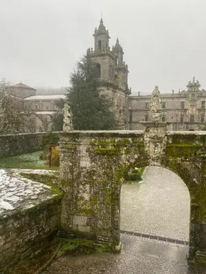 an old stone bridge with a building in the background at Pension A Casiña D,avoa Oseira in Osera