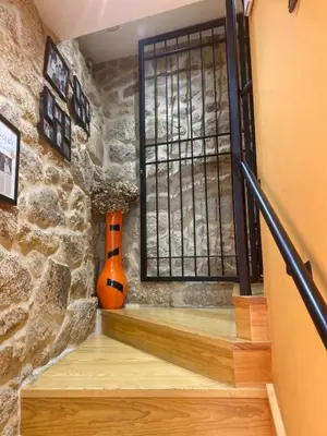 an orange vase sitting on the stairs next to a window at Pension A Casiña D,avoa Oseira in Osera