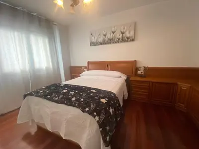 a bedroom with a bed with a black and white blanket at Alojamiento Camiña in Caldas de Reis