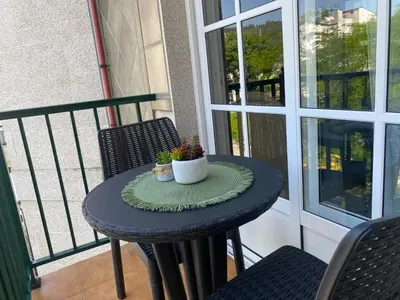 a small table on a balcony with a plant on it at Alojamiento Camiña in Caldas de Reis