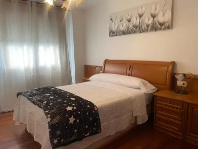 a bedroom with a bed and a dresser and a window at Alojamiento Camiña in Caldas de Reis