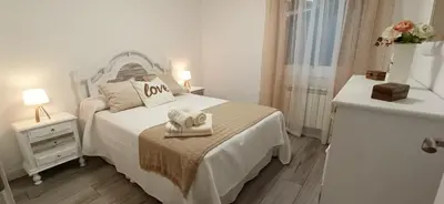a white bedroom with a bed with a towel on it at Eido do Avelán in Mondariz
