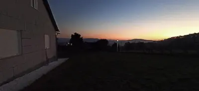 a sunset in a field next to a building at Eido do Avelán in Mondariz