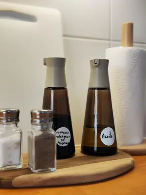 three bottles of spices on a wooden cutting board at White & Wood Miño Apartament in Miño