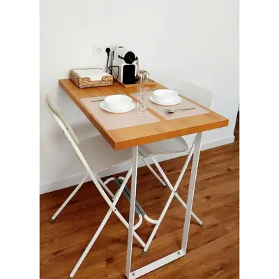 a wooden table with two white chairs and a table at White & Wood Miño Apartament in Miño
