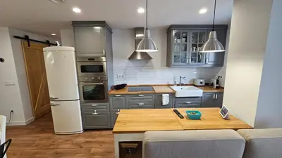 a kitchen with a refrigerator and a table in it at Costa verde asturiana - VUT4692AS in El Espín
