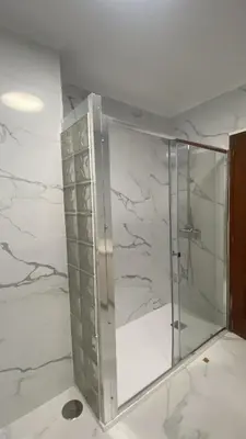 a glass elevator in a room with white marble at Royal Street Refuge in Caldas de Reis