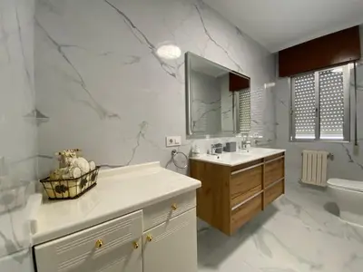 a white bathroom with a sink and a toilet at Royal Street Refuge in Caldas de Reis