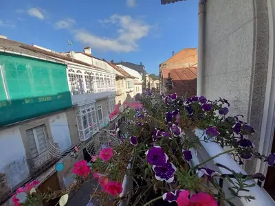 a balcony with flowers on the side of a building at Royal Street Refuge in Caldas de Reis