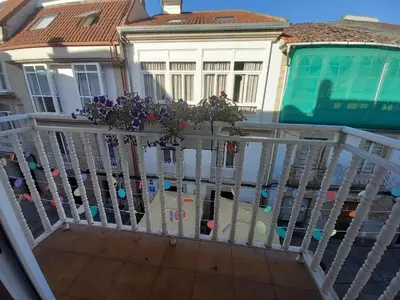 a white railing with purple flowers on a house at Royal Street Refuge in Caldas de Reis