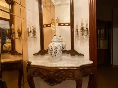 a vase on a table in front of a mirror at Royal Street Refuge in Caldas de Reis