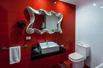 a red bathroom with a sink and a mirror at Motel Venus La Coruña in Guísamo