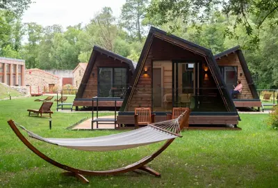 a hammock in front of a tiny house at Luar do Sarela Rooms in Santiago de Compostela