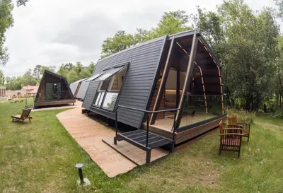 a large black tiny house with a deck at Luar do Sarela Rooms in Santiago de Compostela