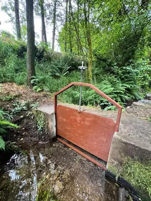a metal gate with a cross on the side of a creek at Luar do Sarela Rooms in Santiago de Compostela