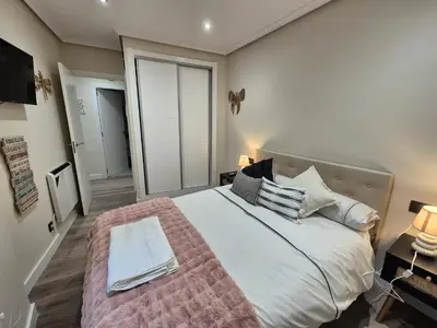 a bedroom with a large bed and two lamps at Máximo Meridio in Ourense