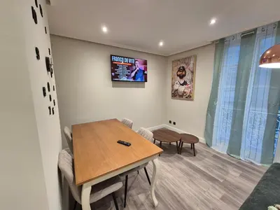 a dining room with a table and chairs and a tv at Máximo Meridio in Ourense