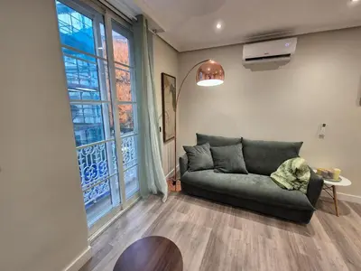 a living room with a couch and a large window at Máximo Meridio in Ourense