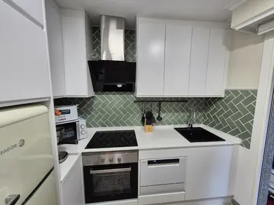 a kitchen with white cabinets and a stove top oven at Máximo Meridio in Ourense