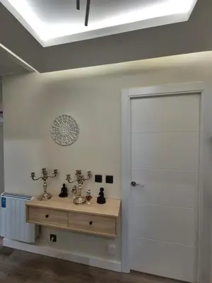 a room with a white door and a wooden table at Máximo Meridio in Ourense