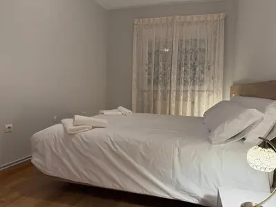 a bedroom with a white bed with towels on it at Santa María in Lugo