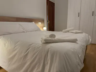 a white bed with towels on top of it at Santa María in Lugo