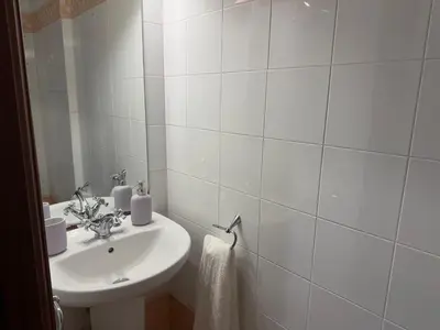 a bathroom with a sink and a white tiled wall at Santa María in Lugo