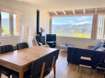a living room with a table and chairs and a large window at Mirador de la Montaña Mágica in El Acebo de San Miguel