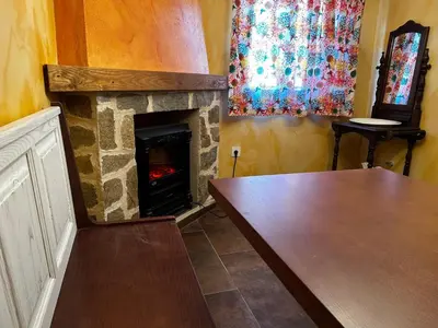 a living room with a fireplace and a table at El tejo milenario in Requejo