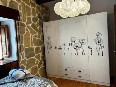 a bedroom with a dresser with drawings of flowers on it at El tejo milenario in Requejo