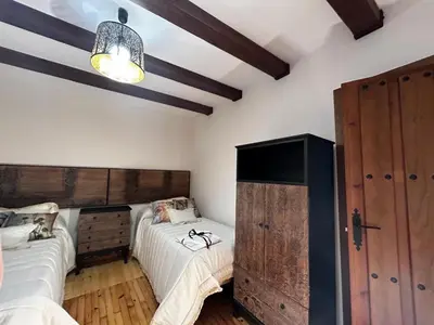 a bedroom with two twin beds and a chandelier at El tejo milenario in Requejo