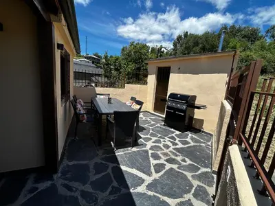 a patio with a grill and a table on a balcony at El tejo milenario in Requejo