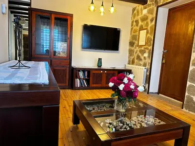 a living room with a table with a vase of flowers at El tejo milenario in Requejo