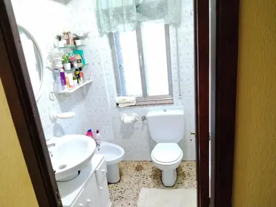 a white bathroom with a toilet and a sink at Casa albergue Pty in Sarria