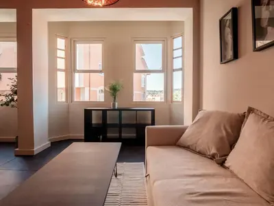 a living room with a couch and two windows at La Fantástica Pontedeume 1 in Puentedeume