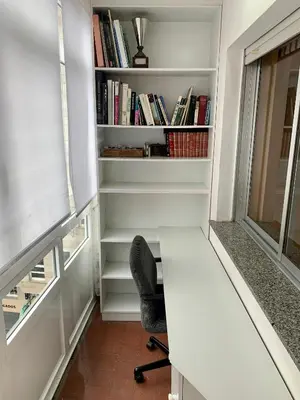 a desk and a chair in a room with bookshelves at Loft Lugo Centro in Lugo