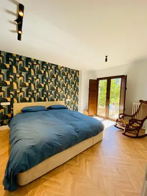 a bedroom with a large bed and a chair at Casa boutique-rural en El Bierzo in Torre del Bierzo