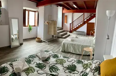 a room with two beds and a staircase at Apartamento con vistas al río in Betanzos
