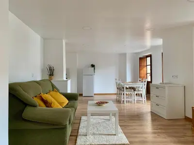 a living room with a green couch and a table at Apartamento con vistas al río in Betanzos