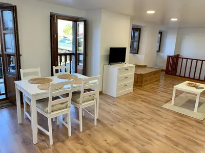 a living room with a table and chairs and a television at Apartamento con vistas al río in Betanzos