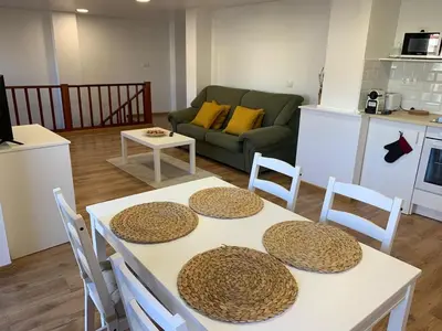 a kitchen and a living room with a table and chairs at Apartamento con vistas al río in Betanzos