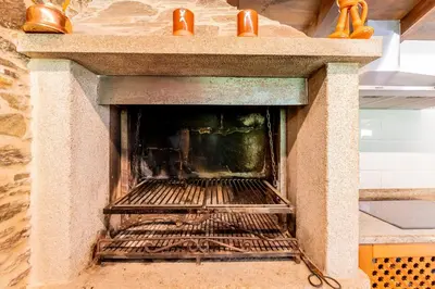a stone oven with a fire inside of it at Lagar de Beuvas in Camanzo
