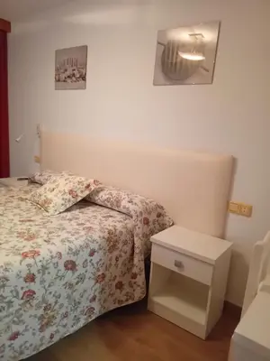a small bedroom with a bed and a night stand at El Ancla in Ponferrada