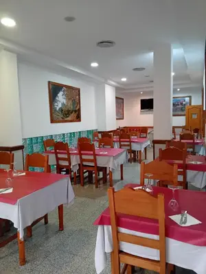 a dining room with red and white tables and chairs at El Ancla in Ponferrada