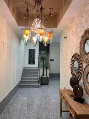 a hallway with a staircase and chandeliers at Aparthotel A&M VIÑA II in Jove